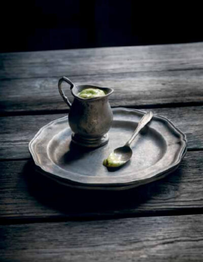 Green goddess dressing with dark table and metal plate